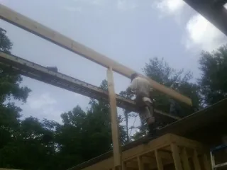 Carpenter setting a ridge beam over a new addition frame — Ice Dam Removal by Roofing Brothers in Sebago