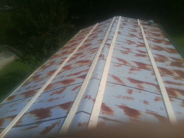 Rusted metal roof panels with new wood purlins before replacement — Storm Damage Roof Repair in Sebago by Roofing Brothers
