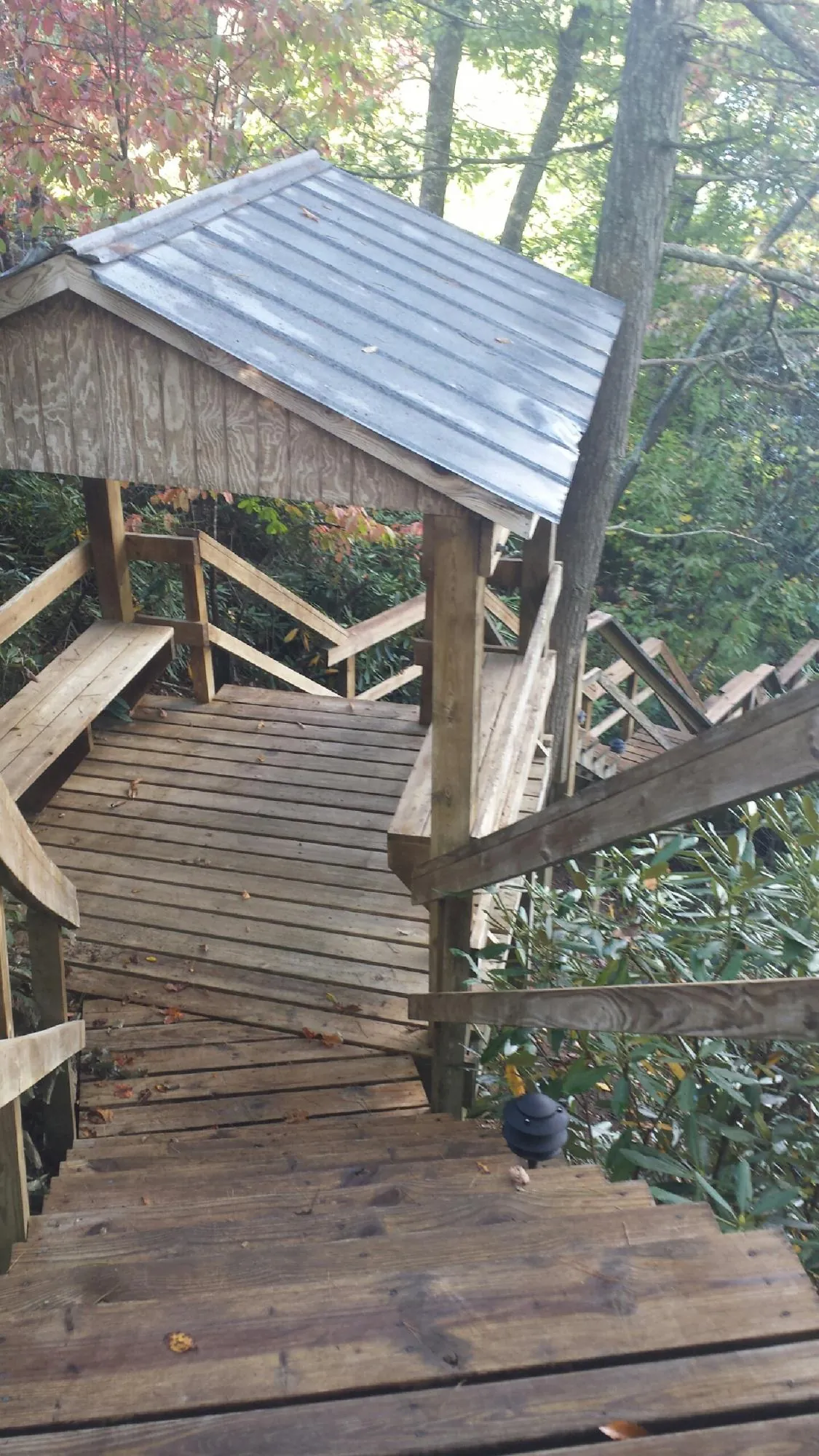 Metal roofed shelter over wooden steps on a wooded walkway — Skylight Repair & Installation work by our crew in Sebago
