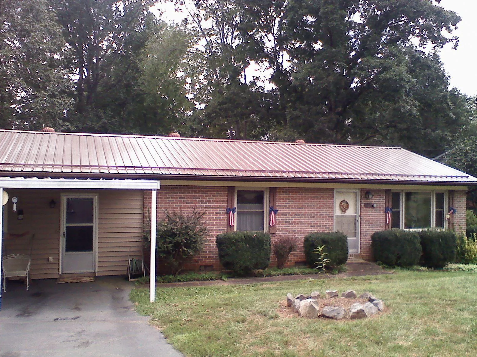 Bronze metal roof and carport on a brick ranch home — Roof Repair work by our crew in Sebago